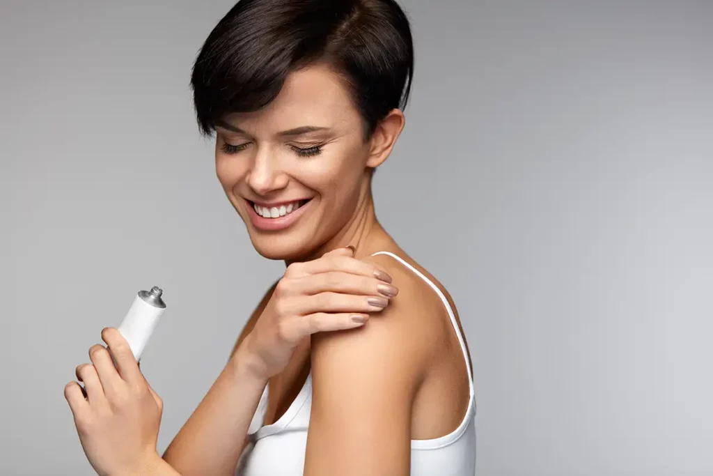 woman applying hormone cream to her shoulder