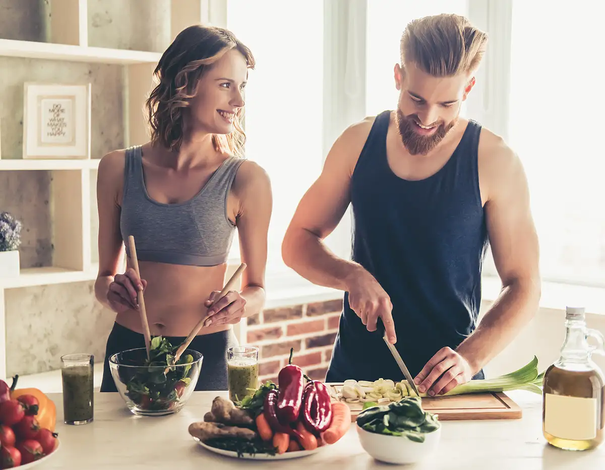 healthy man and woman preparing a meal in their kitchen.